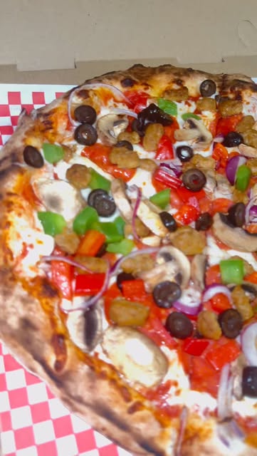 A loaded pizza from Giani’s Oven with peppers, mushrooms and olives